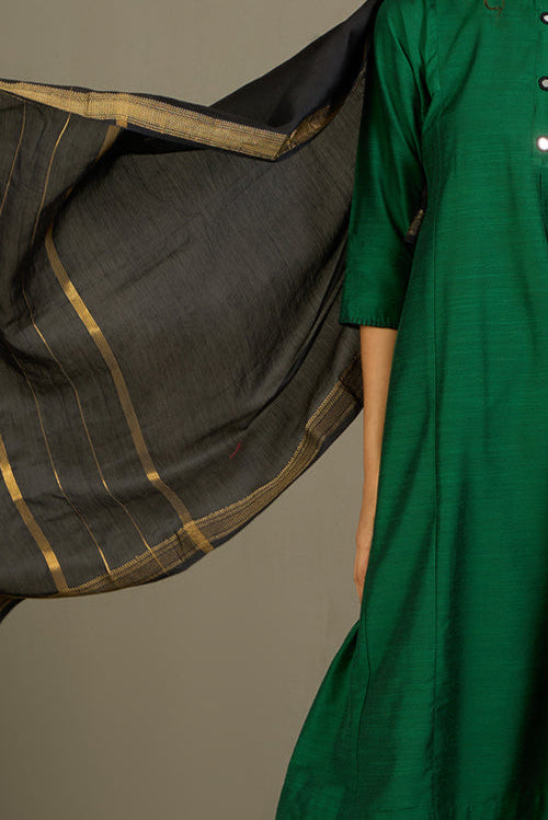 Woman wearing a pink traditional outfit with a black dupatta against a beige background
